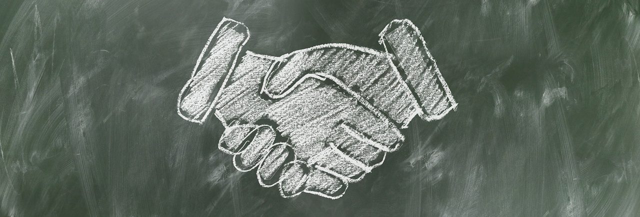 Handshake sketch drawn on chalkboard